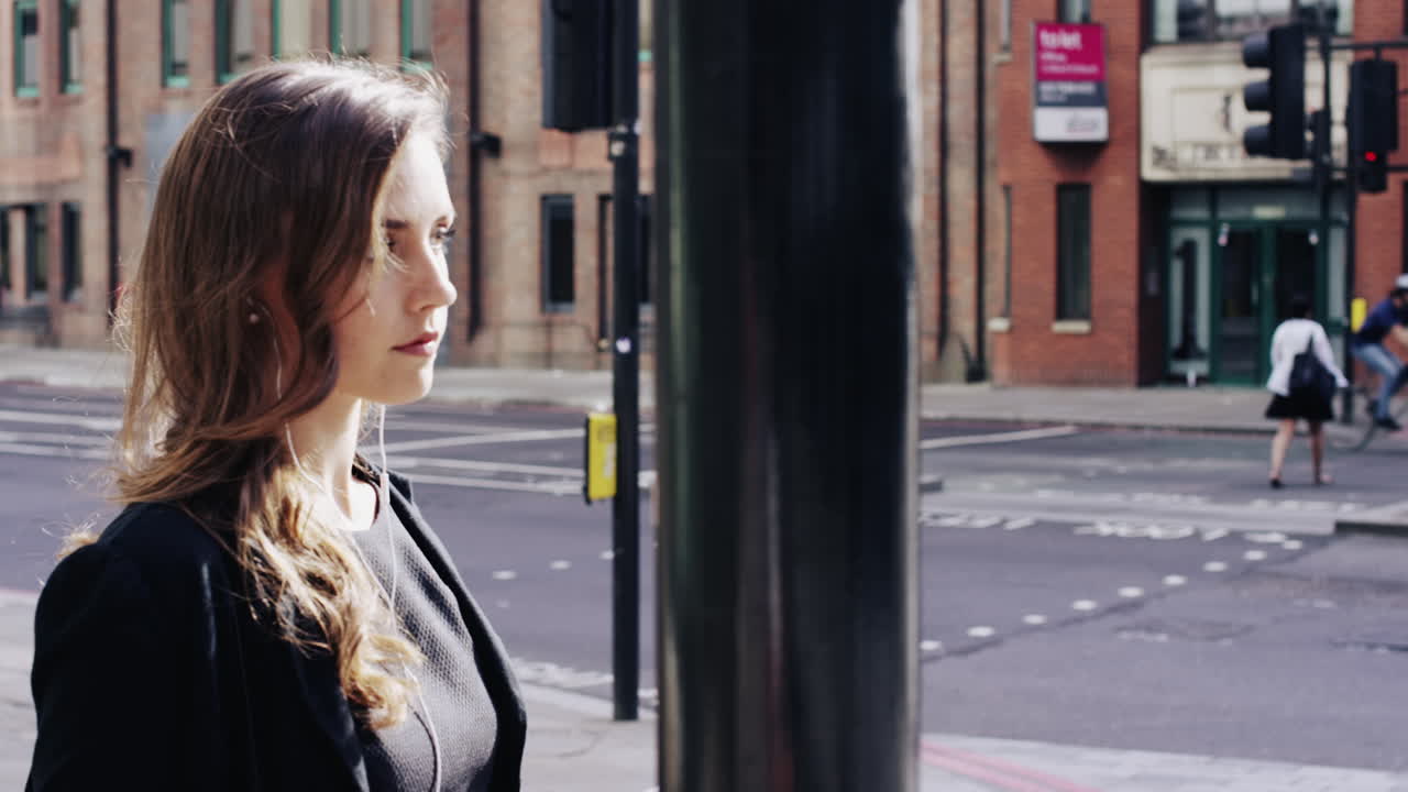 Attraktiv forretningskvinne som pendler, bruker smarttelefon mens hun går i London.