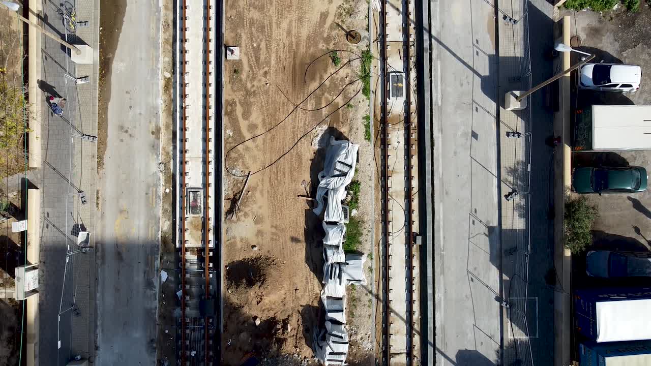 흙과 콘크리트로 둘러싸인 이스라엘 자파에서 건설 중인 빈 경전철의 공중 슬로우 포워드 드론 샷