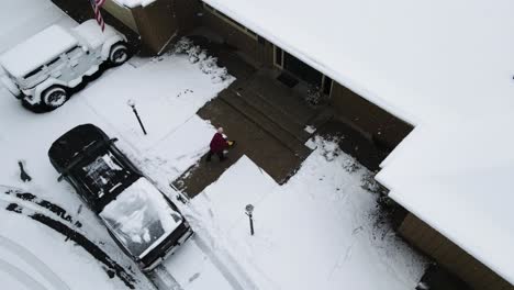 Schnee-Von-Einer-Veranda-Aus-Einem-Hohen-Winkel-Mit-Einer-Drohne-Schaufeln