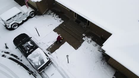 shoveling snow off of a porch from high angle with drone