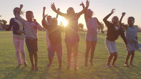 leerlingen van de basisschool springen buiten bij zonsondergang.