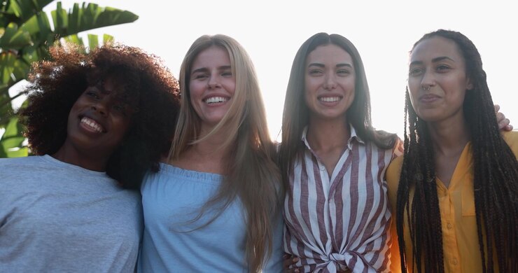 Giovani donne felici multietniche che sorridono insieme all'aperto
