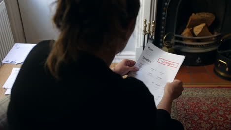 an unrecognizable female opening a debt letter