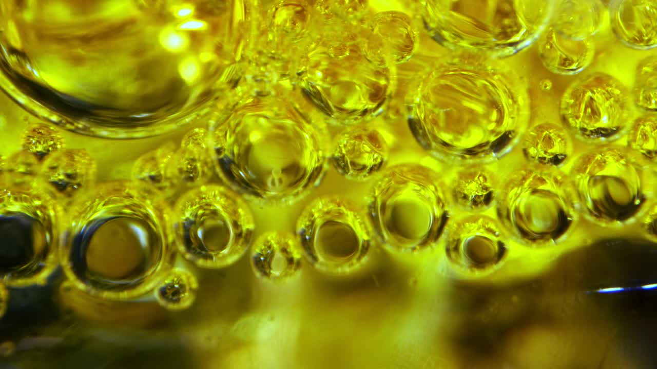 유리 뒤에 잉크가 있는 기름과 물에 있는 거품