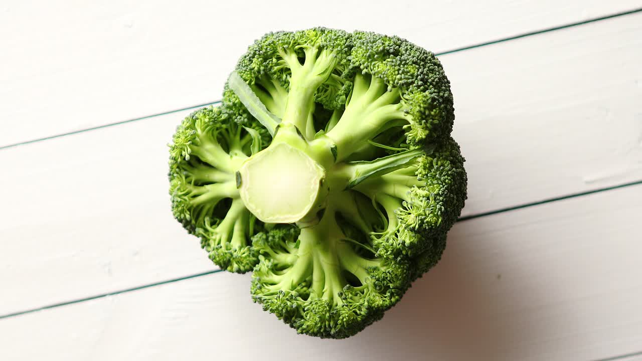 Top view of green  fresh  raw broccoli placed on white wooden table