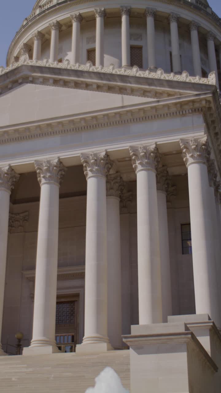 Inquadratura cinematografica verticale in tilt up da una fontana che rivela la cupola del Campidoglio del West Virginia con movimento fluido di gimbal e luce naturale