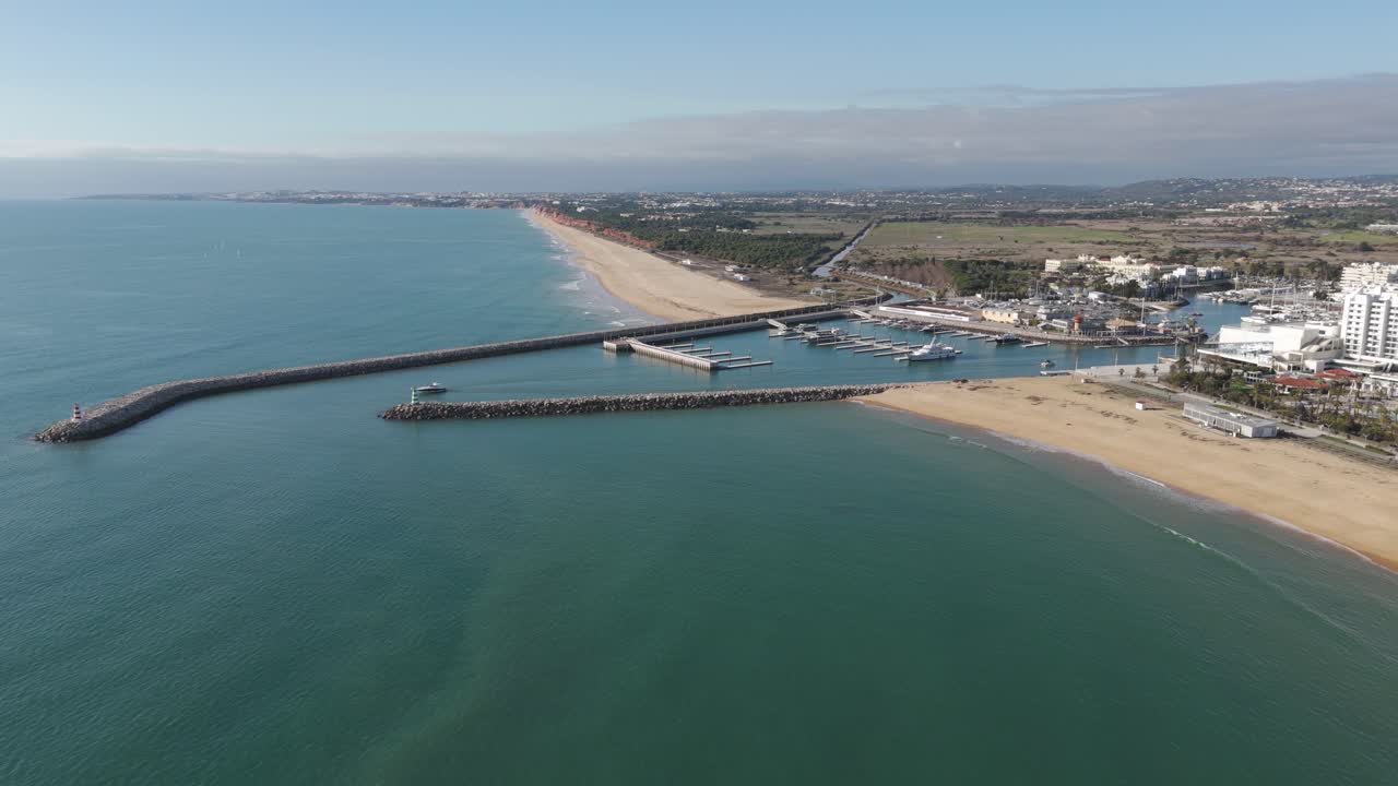 Vista aérea da Marina de Vilamoura, exibindo a praia e os cais ao longo da costa do Algarve