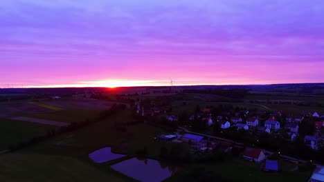 Panorama-Al-Atardecer-Un-Dron-Vuela-Sobre-Lagos-Prados-Y-Casas