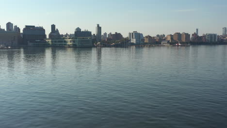 A-low-angle-drone-shot-over-a-calm-Hudson-River-at-sunrise