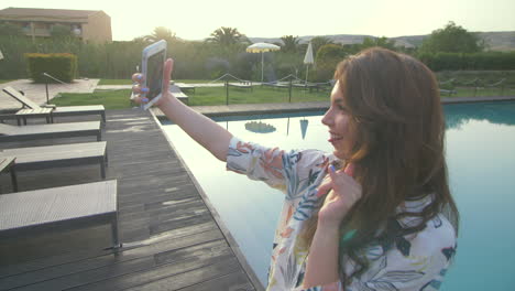 woman takes a selfie by the pool