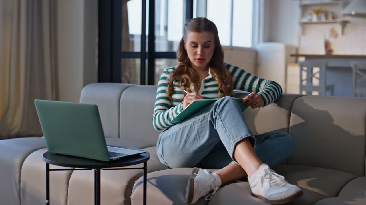 Online psychologist listening client by laptop video call at home. Woman writing