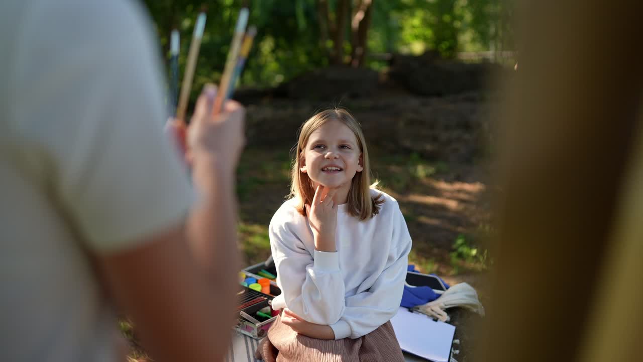 chica pintando al aire libre con un tutor