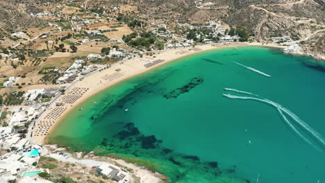 Vista-Aérea-De-Los-Deportes-Acuáticos-En-La-Playa-De-Mylopotas-En-La-Isla-De-Ios,-Grecia