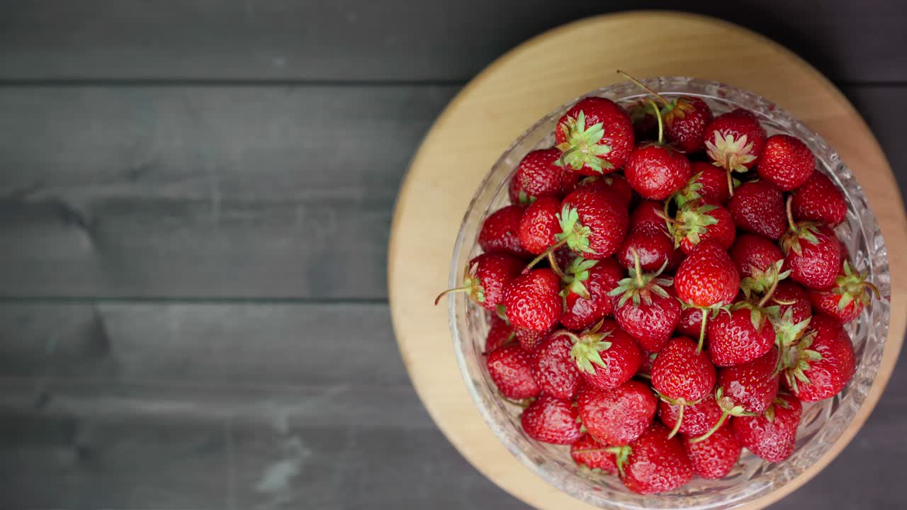 Strawberries in a bowl on a wooden background