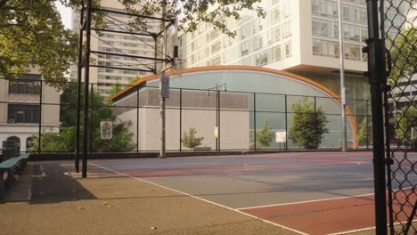 pov dolly shot of empty basketball court in new york city during sunny day