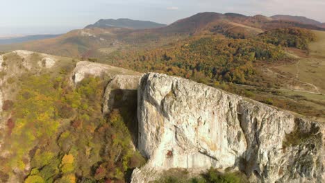 Luftschwenk-Hochwinkelaufnahme-Eines-Großen-Hohen-Felsens-Am-Rande-Eines-Berges-6