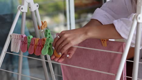 person attaching clothespins to a drying rack