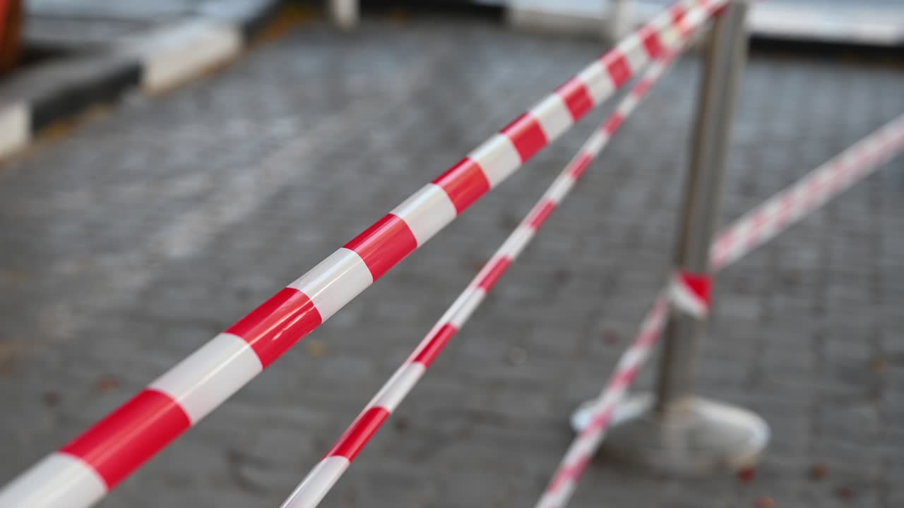 4k: cinta roja y blanca de la policía, no cruzar bloqueando la calle de la ciudad, manifestación, protesta o escena del crimen