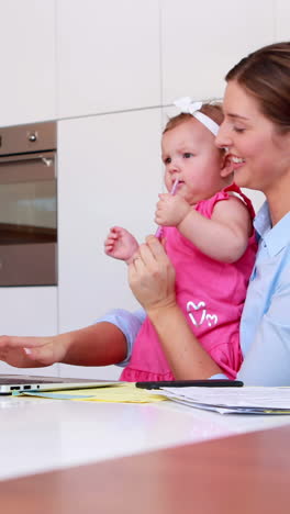 mujer de negocios con su bebé usando una computadora portátil