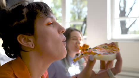 Cerca-De-Dos-Niñas-Felices-Bebiendo-Vino-Y-Compartiendo-Pizza-En-Casa