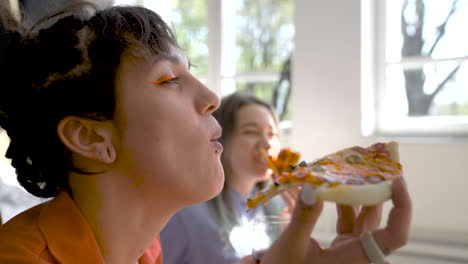 Close-Up-Of-Two-Happy-Girls-Drinking-Wine-And-Sharing-Pizza-At-Home