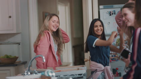 happy group of teenage girls dancing in kitchen having fun celebrating together enjoying hanging out together on party weekend