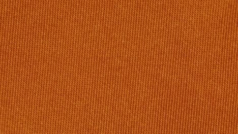 tangerine color plain textured fabric. - closeup shot