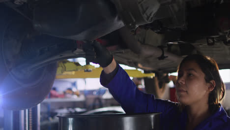 animación de una mujer adulta asiática mecánica drenando aceite del motor del coche en el garaje