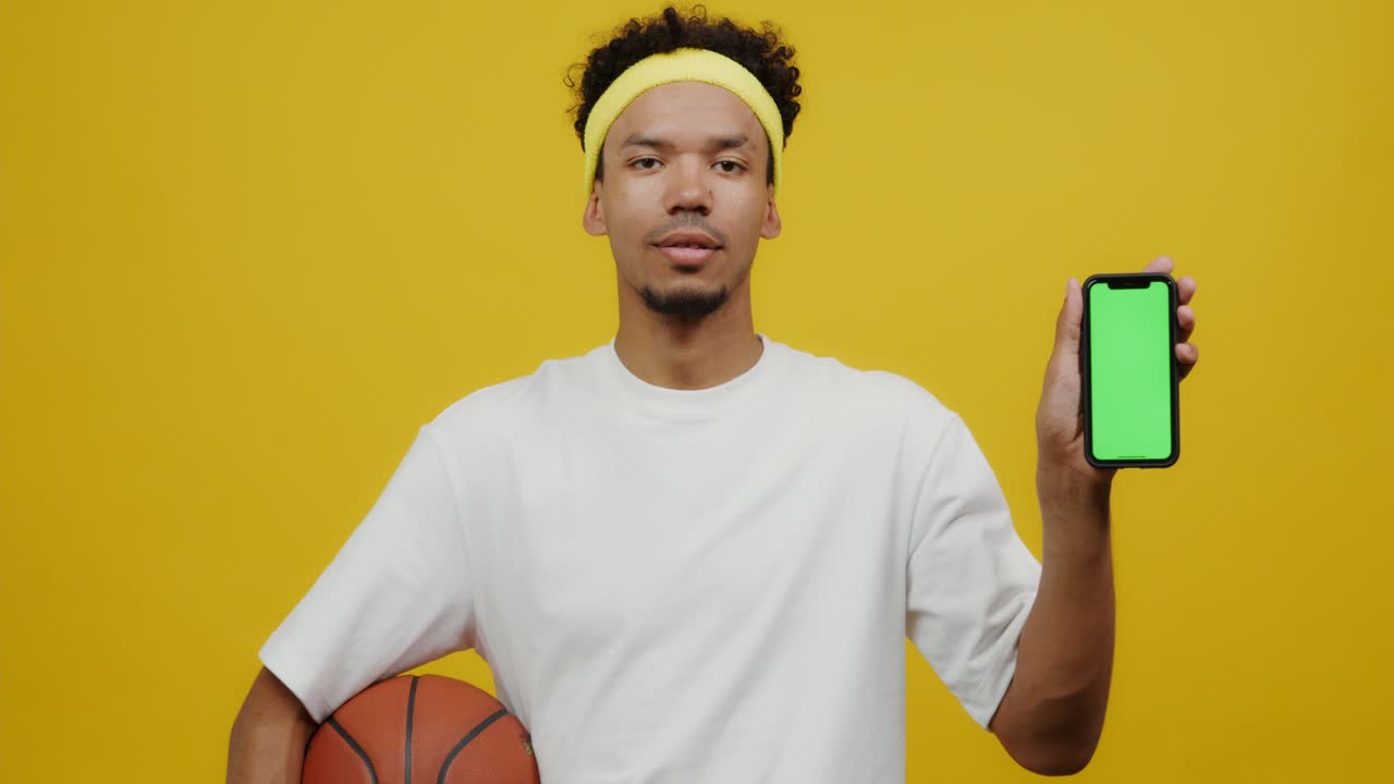 hombre con baloncesto y teléfono inteligente con pantalla verde