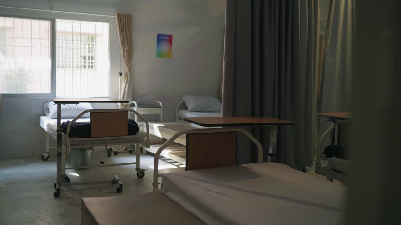 Revealing shot of hospital vacant beds with sunlight coming in a hospital of Pakistan.