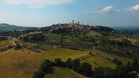 drone flight above of the medieval mediterranean town san gimignano near siena, a masterpiece of historic architecture in the idyllic landscape of tuscany, italy with vineyards and olive trees