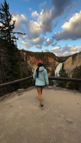 Vertical-4k,-Young-Woman-Lower-Falls-Lookout-in-Yellowstone-National-Park,-Wyoming-USA