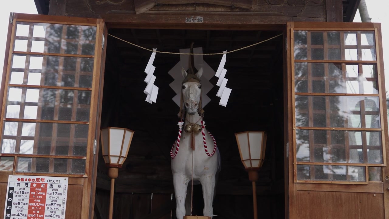 Statua Sacra di Cavallo Bianco Custodita Dietro Corda Shimenawa e Striscioline di Carta in un Santuario Shintoista in Giappone