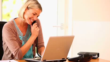 Atractiva-Mujer-Joven-Llamando-Y-Trabajando-En-La-Computadora-Portátil