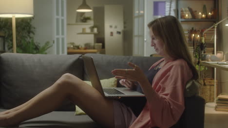 woman talking on web call on laptop at home