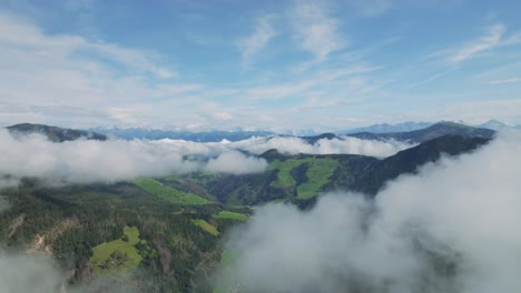 El-Dron-Vuela-Entre-Picos-De-Dolomías,-Velados-Por-Las-Nubes-Sobre-El-Valle-Y-Revela-El-Pueblo-En-El-Valle.