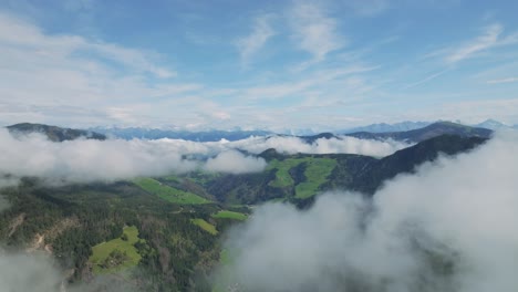 drone soars amidst dolomite peaks, veiled in clouds over la val and it reveals the village in the valley