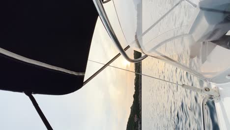 side view from the speedboat while the sun sets behind the island in the distance, croatia