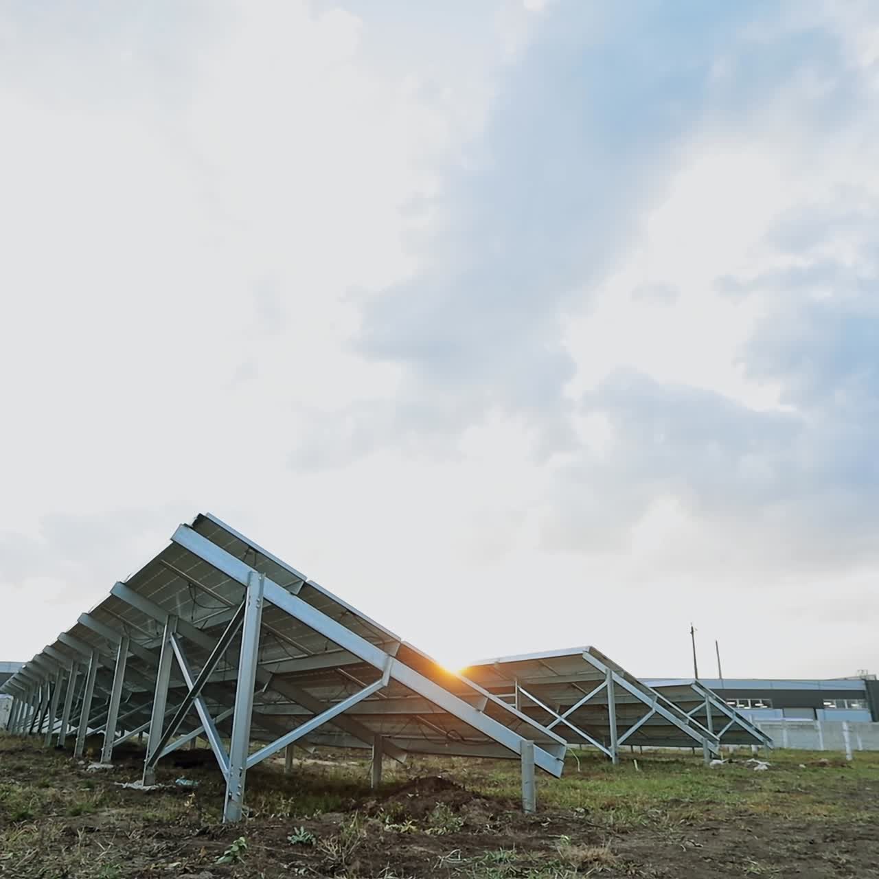 Solar energy farm on the field. Solar panels attached on metal basis on the ground. Renewable source of energy. View from below.