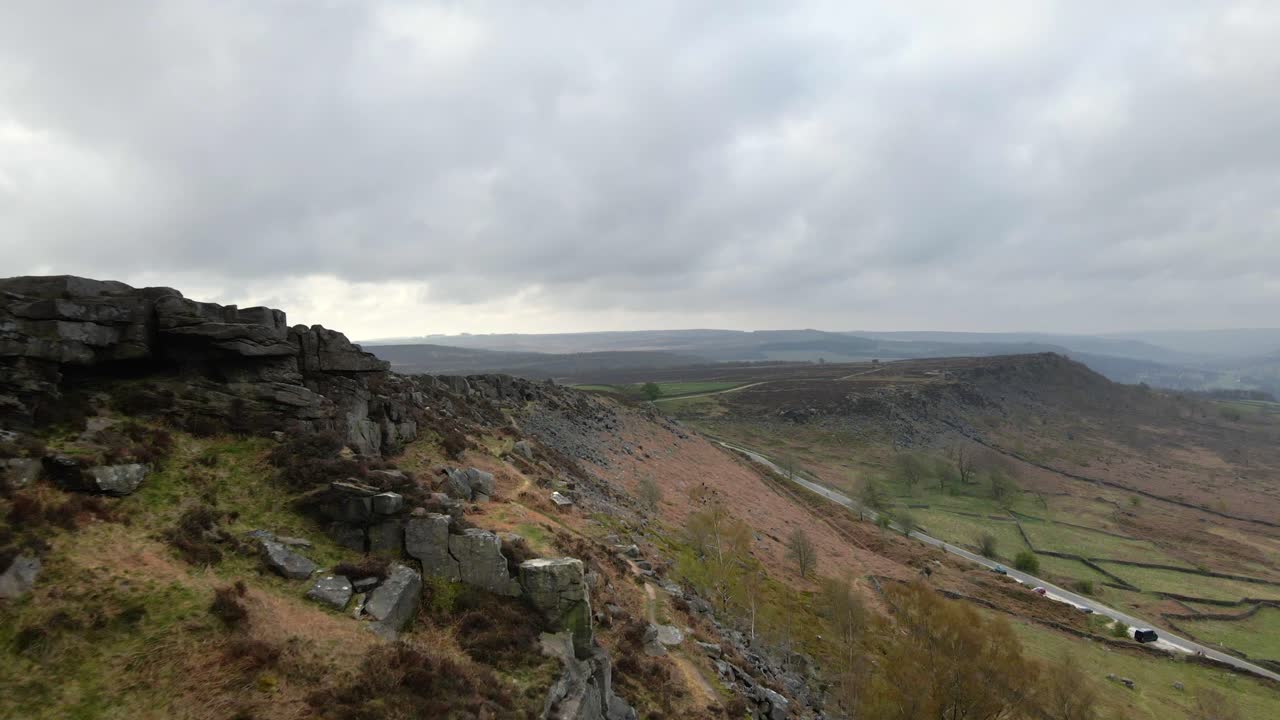 Dramatic rock formations and beautiful, wide open fields at Curbar Edge in the Peak District UK