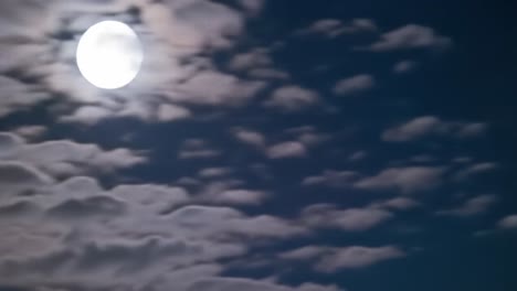 a captivating celestial view showcasing a full moon partially veiled by soft, wispy clouds in a serene night sky, evoking a sense of tranquility and wonder
