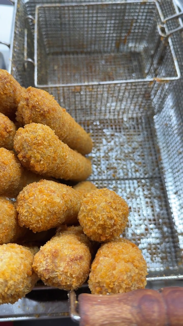Freshly Fried Breaded Food Items in a Metal Deep Fryer Basket