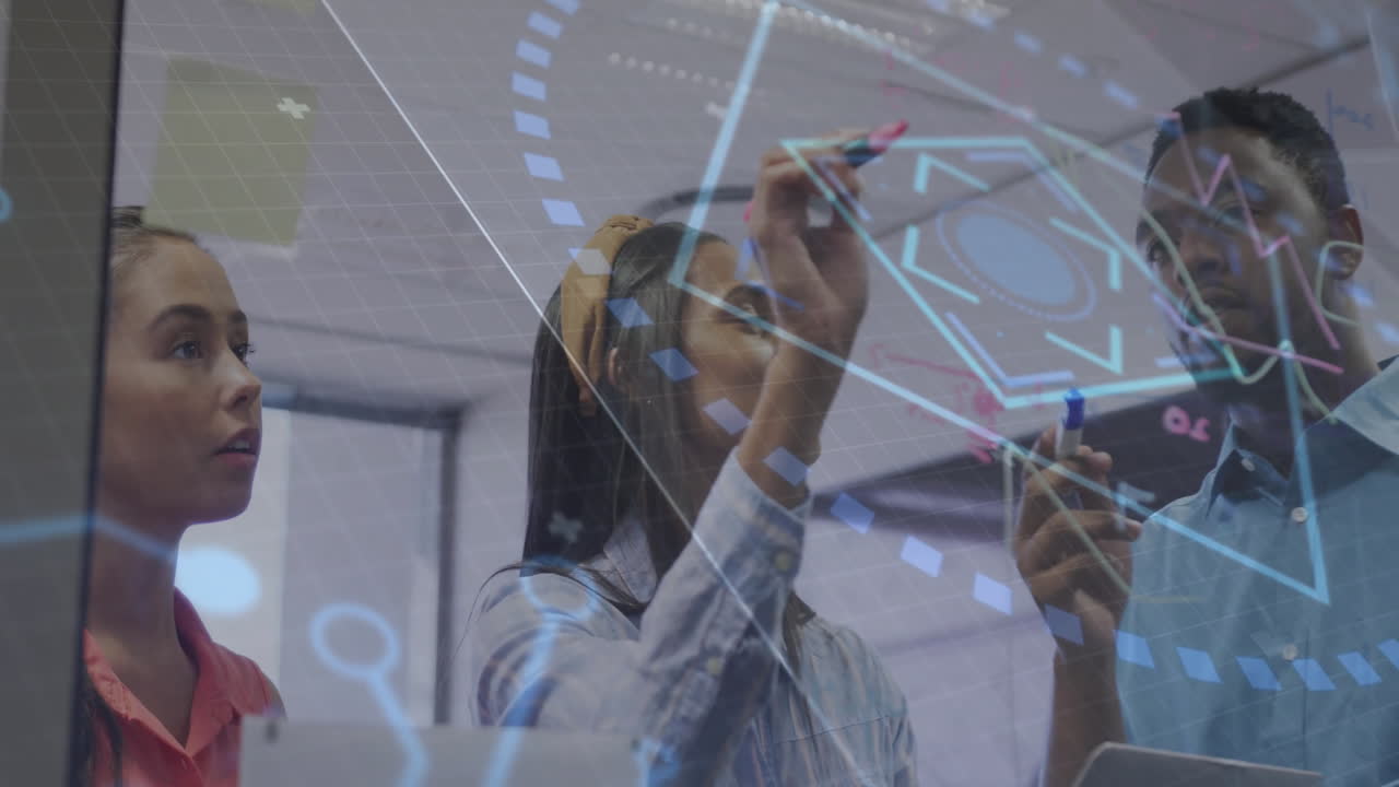 Team members drawing tech diagrams on glass whiteboard with colored markers and digital overlays