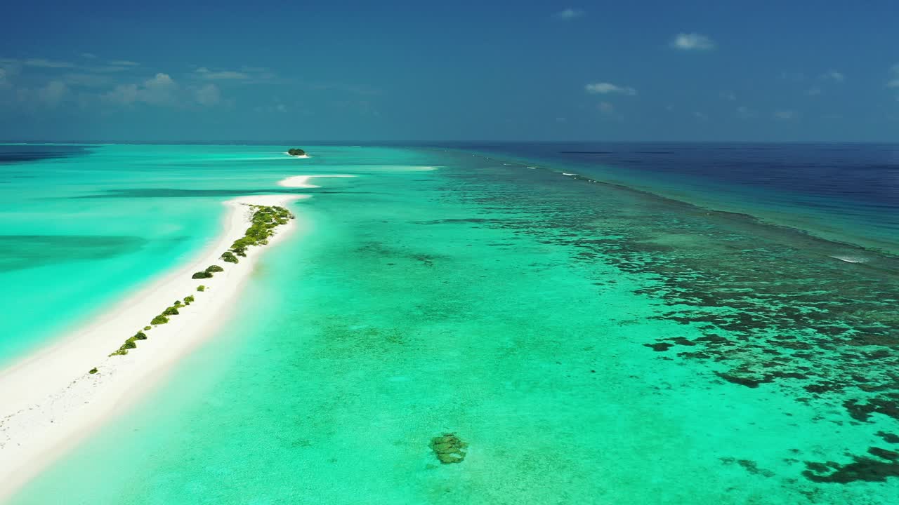longa praia de areia branca cercada por águas turquesas calmas da lagoa rasa e barreira de recifes de coral no meio do oceano azul profundo, maldivas