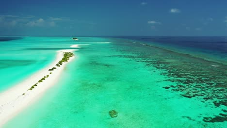 langer weißer sandstrand, umgeben von türkisfarbenem, ruhigem wasser einer flachen lagune und korallenriffen inmitten des tiefblauen ozeans auf den malediven