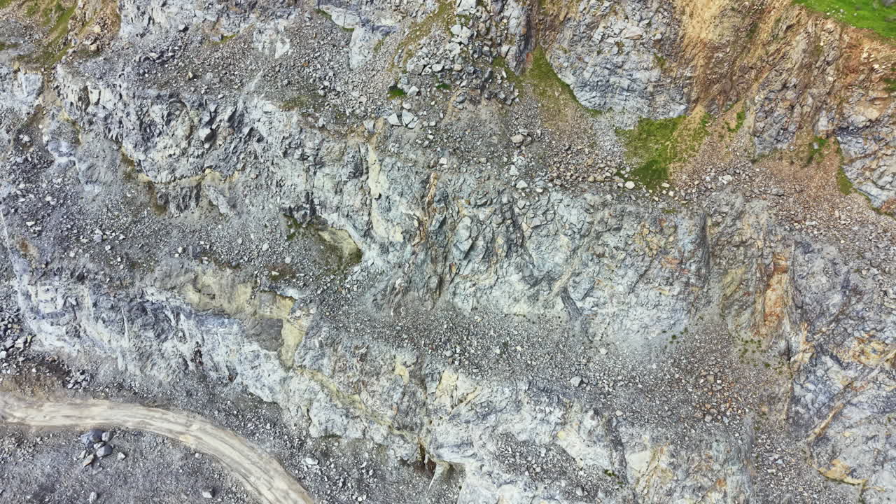 Granitbrud viser store sten og stejle klipper med maskineri og arbejdere involveret i stenbrydning om dagen.