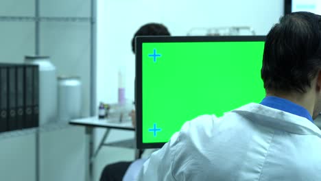 científico masculino hablando de trabajar en un laboratorio moderno o centro médico. monitor de fondo pantalla verde. concepto de ciencia, desarrollo de pruebas y industria de laboratorio.
