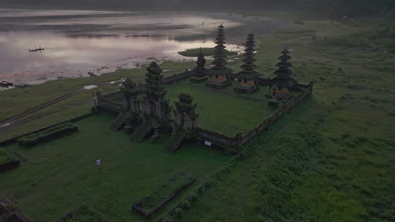 Tidligt lys på Pura Ulun Danu Tamblingan omgivet af tåget sø, Indonesien