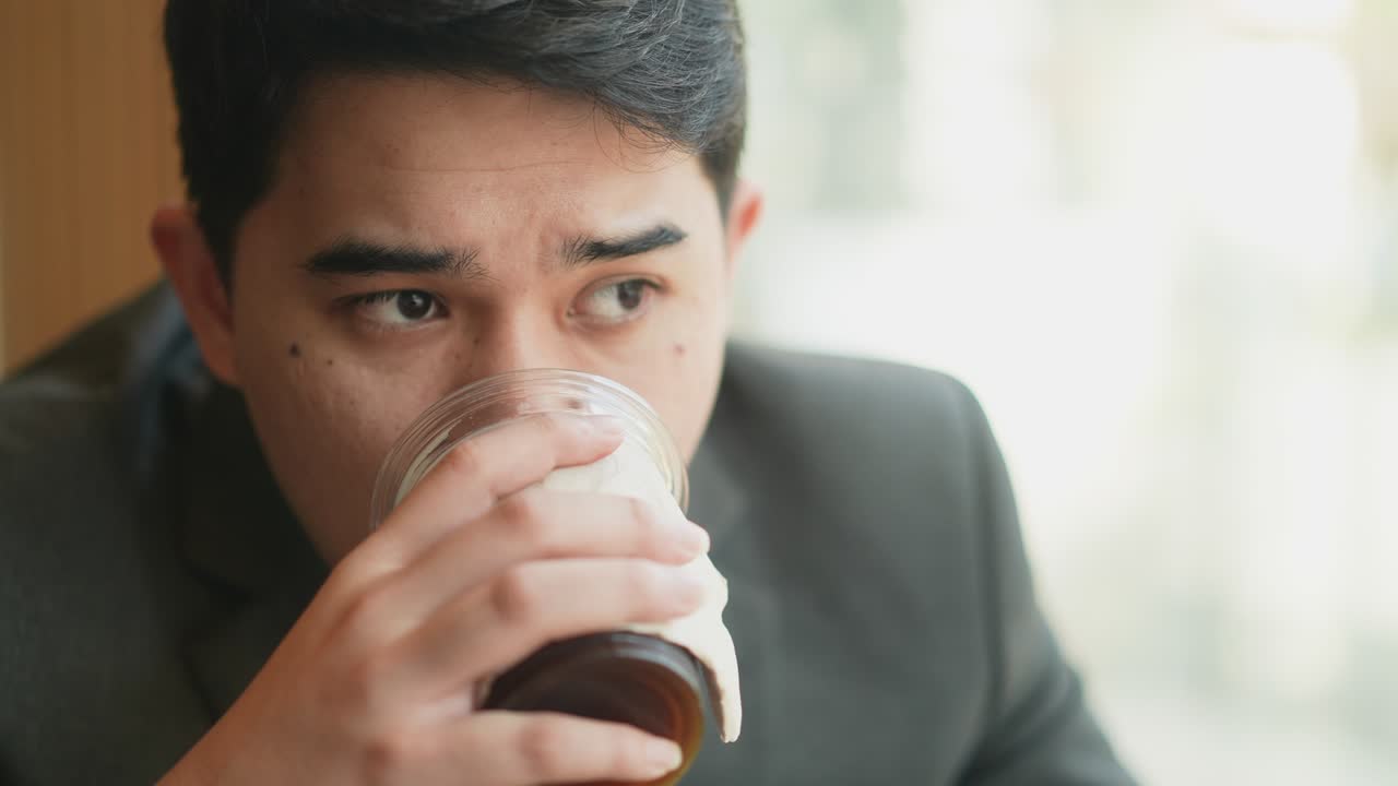 성인 중동 사업가가 뜨거운 커피를 마시며 사무실 창문 밖을 바라보며 미래 사업 개념에 대한 새로운 아이디어를 생각하면서 느린 동작 장면