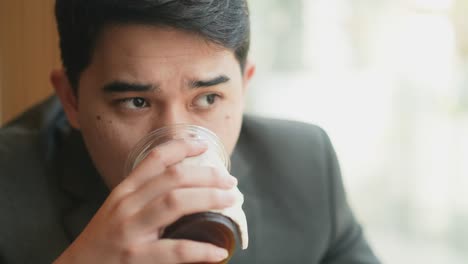 slow motion scene on adult middle east businessman drinking hot coffee and looking outside through the window in the office while thinking new idea for vision of future business concept